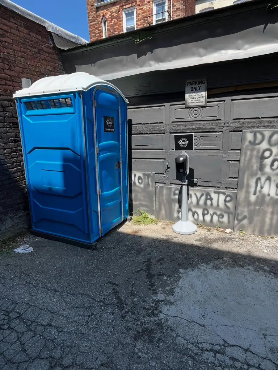 Blue porta potty placed at a jobsite alley