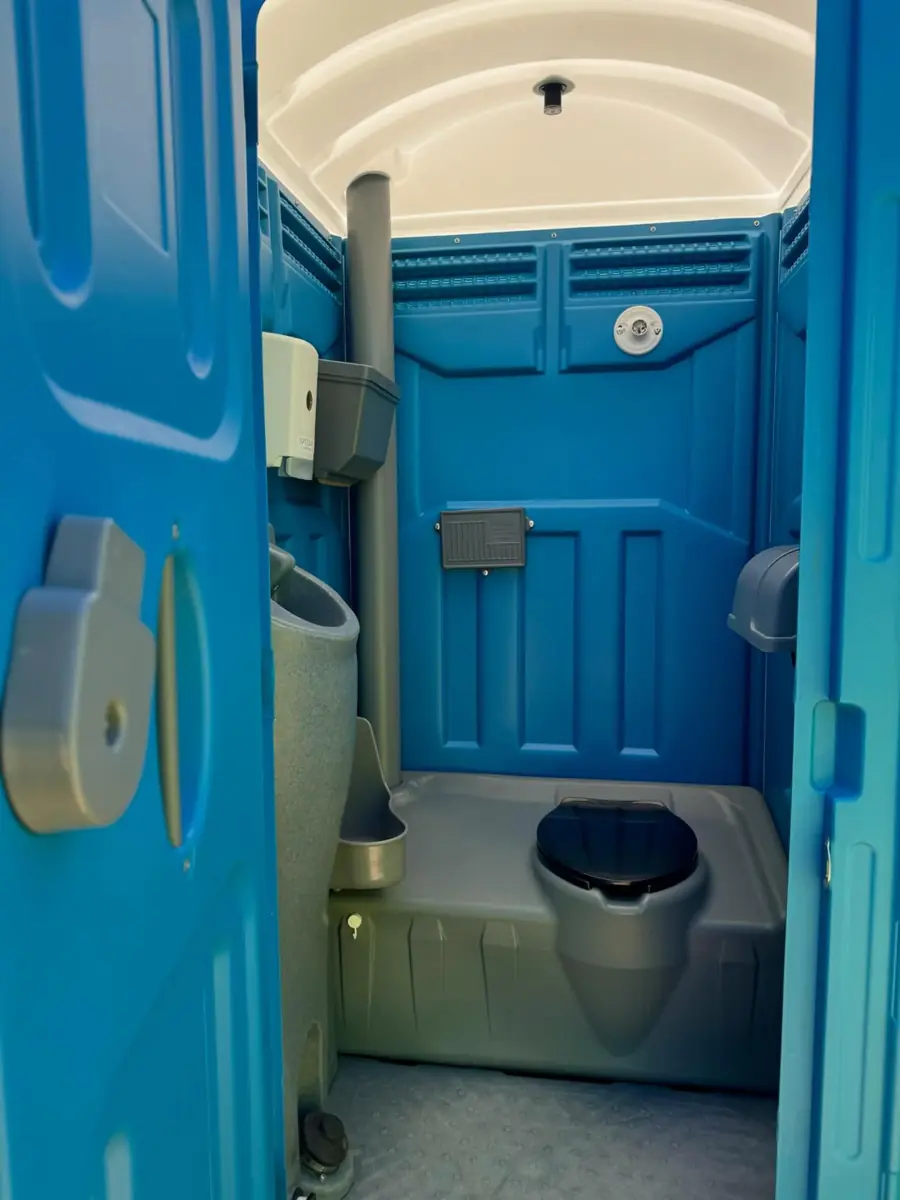 Blue deluxe portable toilet interior with sink and dispensers