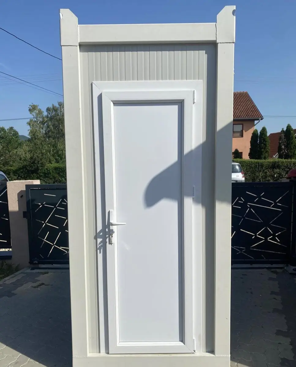 White flushing restroom cabin in a driveway